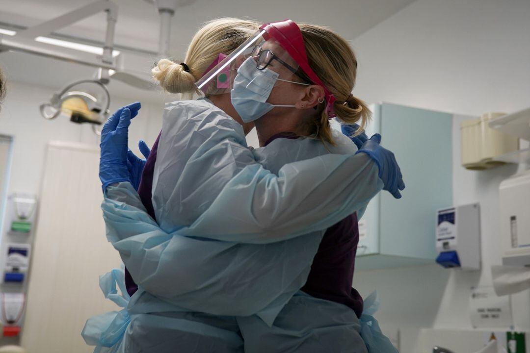 Sanitarios se abrazan en una consulta