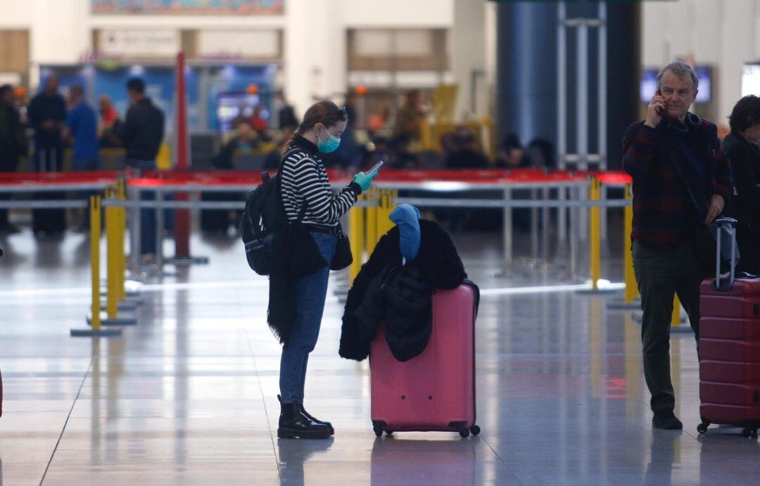 Una turista con mascarilla y guantes en el aeropuerto de Málaga el lunes 16 de marzo de 2020.