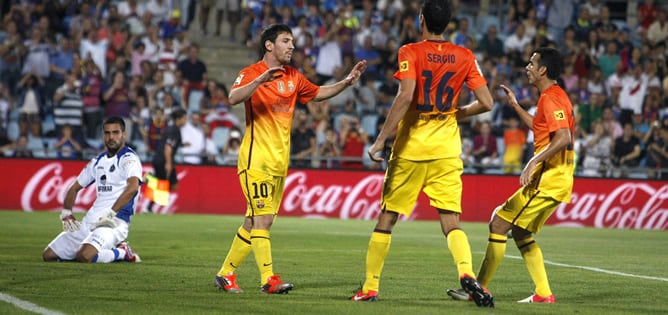 El delantero argentino del Barcelona Leo Messi celebra uno de sus goles con el centrocampista Sergio Busquets y el delantero Pedro Rodríguez en presencia del portero del Getafe, Miguel Ángel Moyá