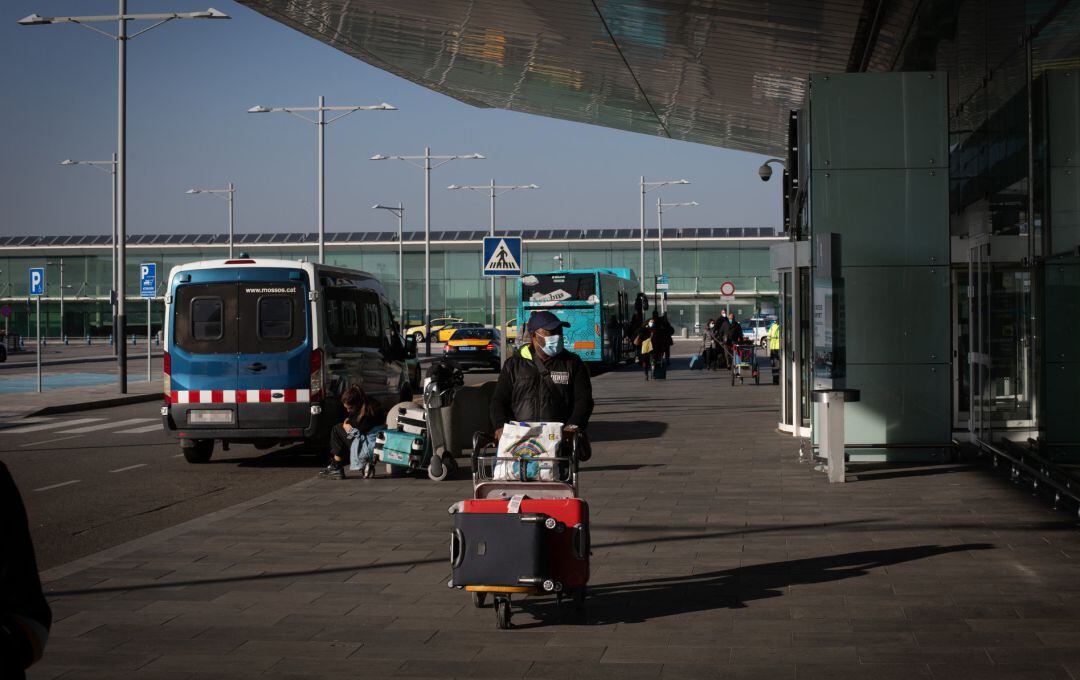 Un hombre con un carro de maletas en las inmediaciones del aeropuerto de El Prat.