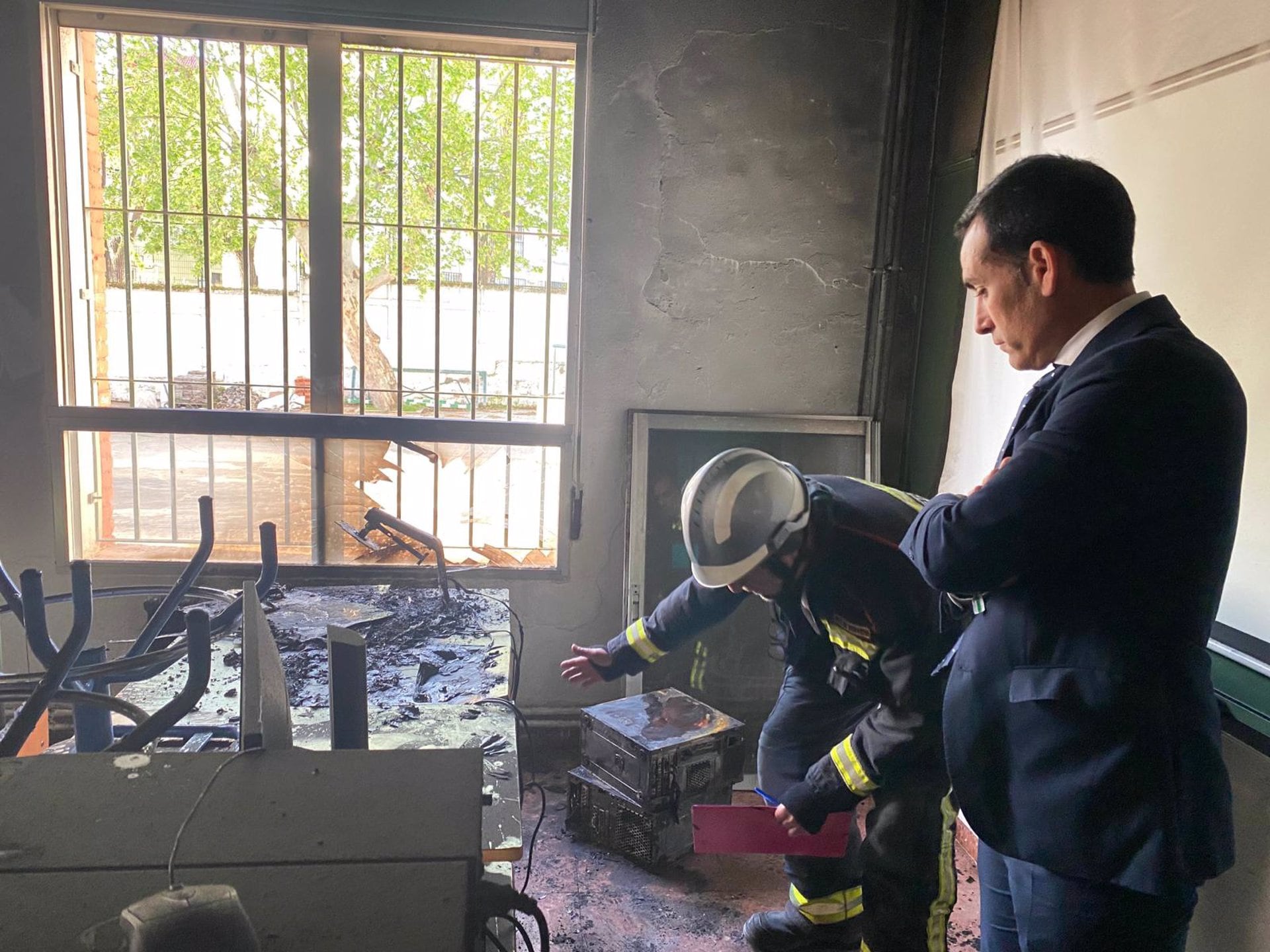 El delegado de Desarrollo Educativo, Francisco José Solano, visita junto a un bombero el aula afectada en el IES Fuente de la Peña