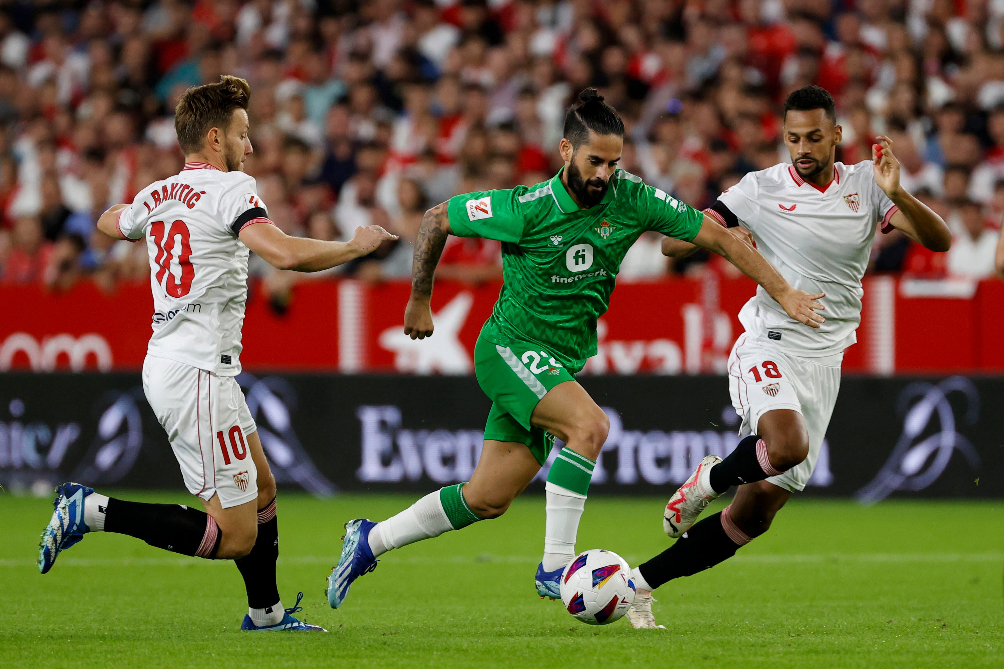 El centrocampista del Betis Francisco Alarcón &quot;Isco&quot; juega un balón entre Ivan Rakitic y Djibril Sow, ambos del Sevilla, durante el partido de LaLiga de fútbol que Sevilla FC y Real Betis disputan este domingo en el estadio Ramón Sánchez Pizjuán.