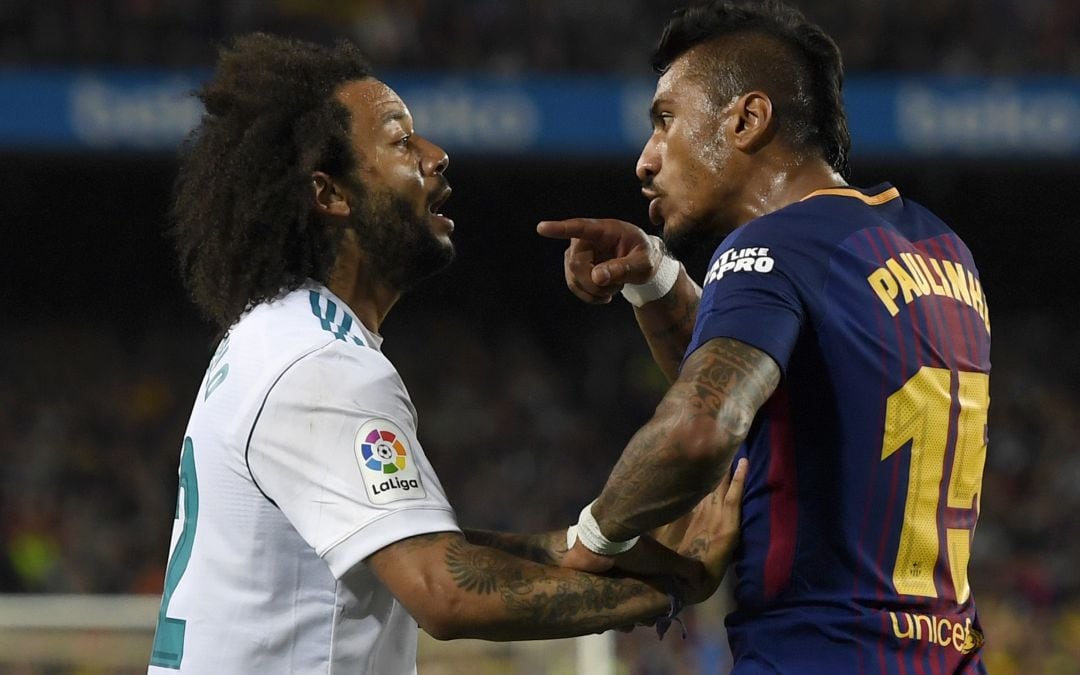 Paulinho (derecha) se encara con Marcelo en un Clásico entre el Real Madrid y el FC Barcelona.