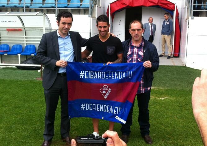 El lateral derecho posa sobre el césped de Ipurua con el presidente del Eibar, Alex Aranzabal, y su director deportivo, Fran Garagarza.