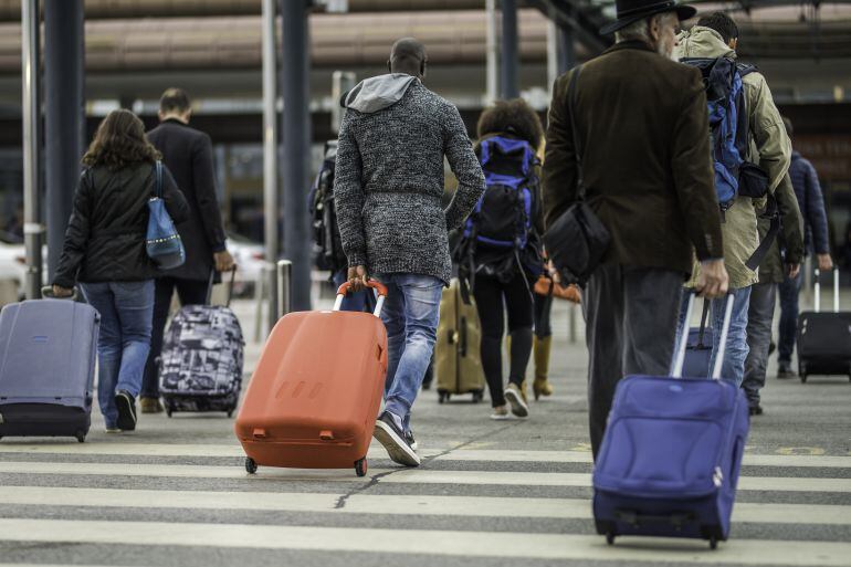 Gente llegando al aeropuerto con sus maletas