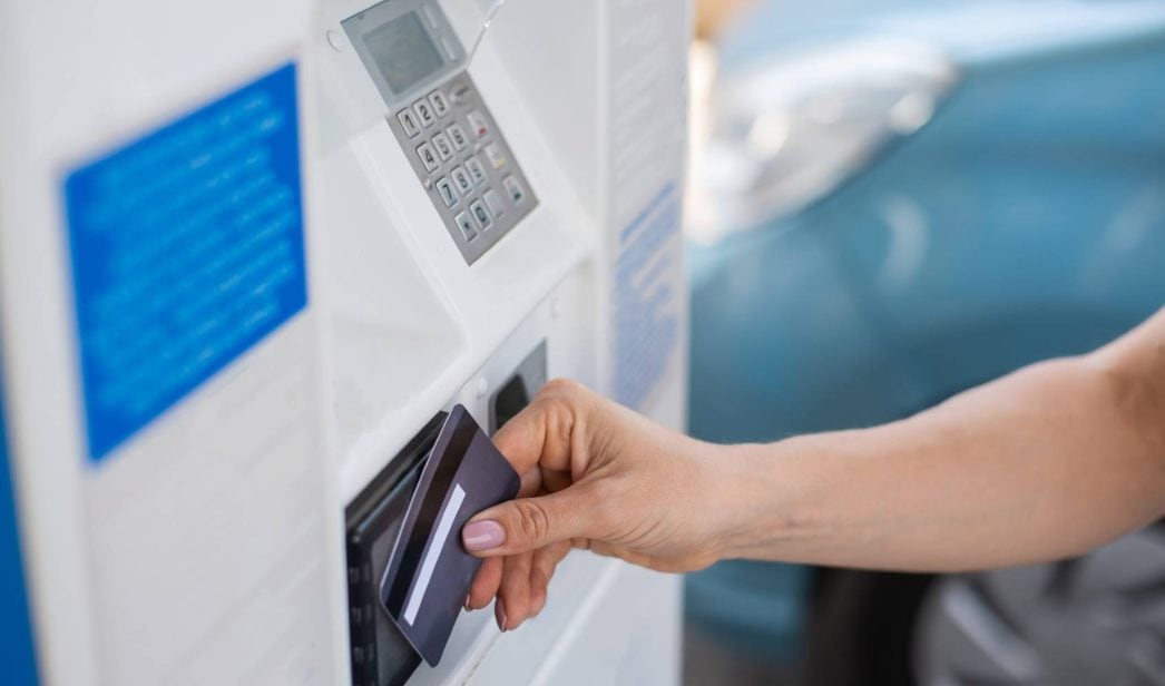 Una conductora, pagando el combustible en una estación de servicio automática