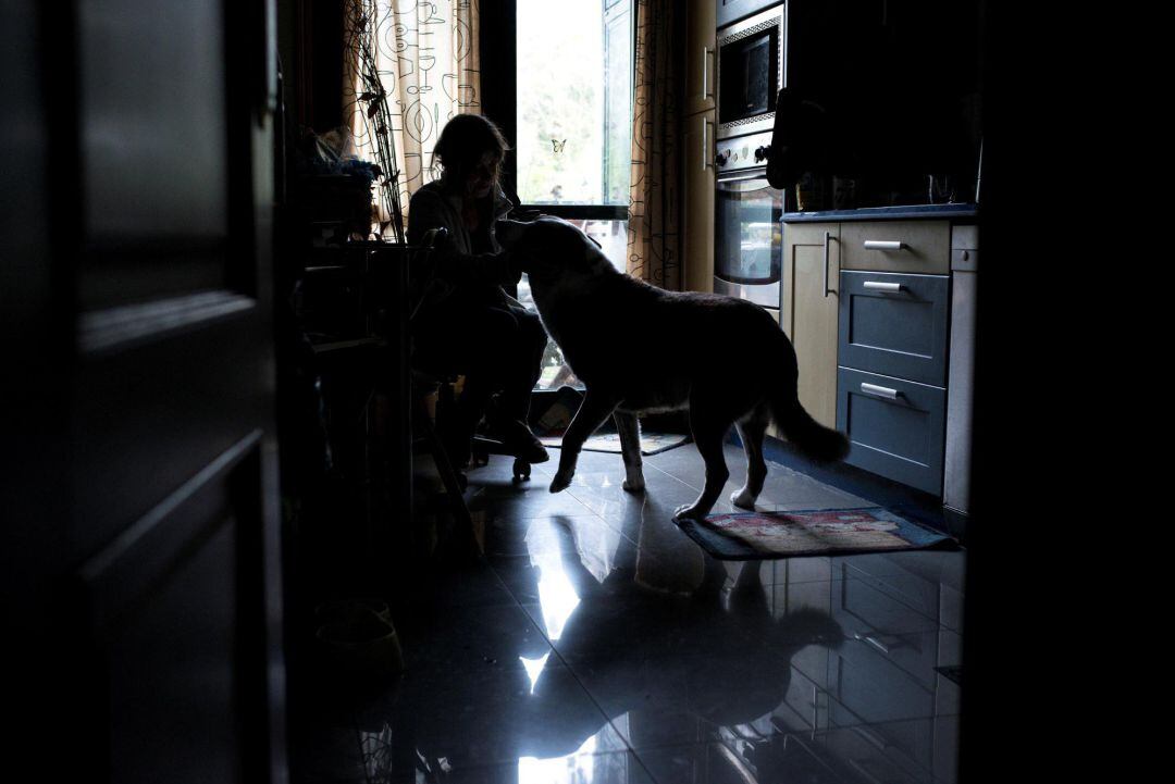 Una mujer acaricia a su perro durante el confinamiento en su casa de Ourense.