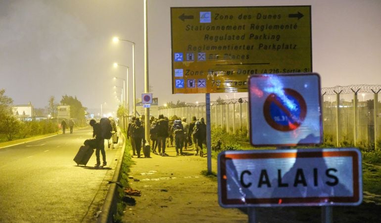 Varios migrantes abandonan &#039;la jungla&#039; de Calais (Francia), que será demolida en los próximos días.