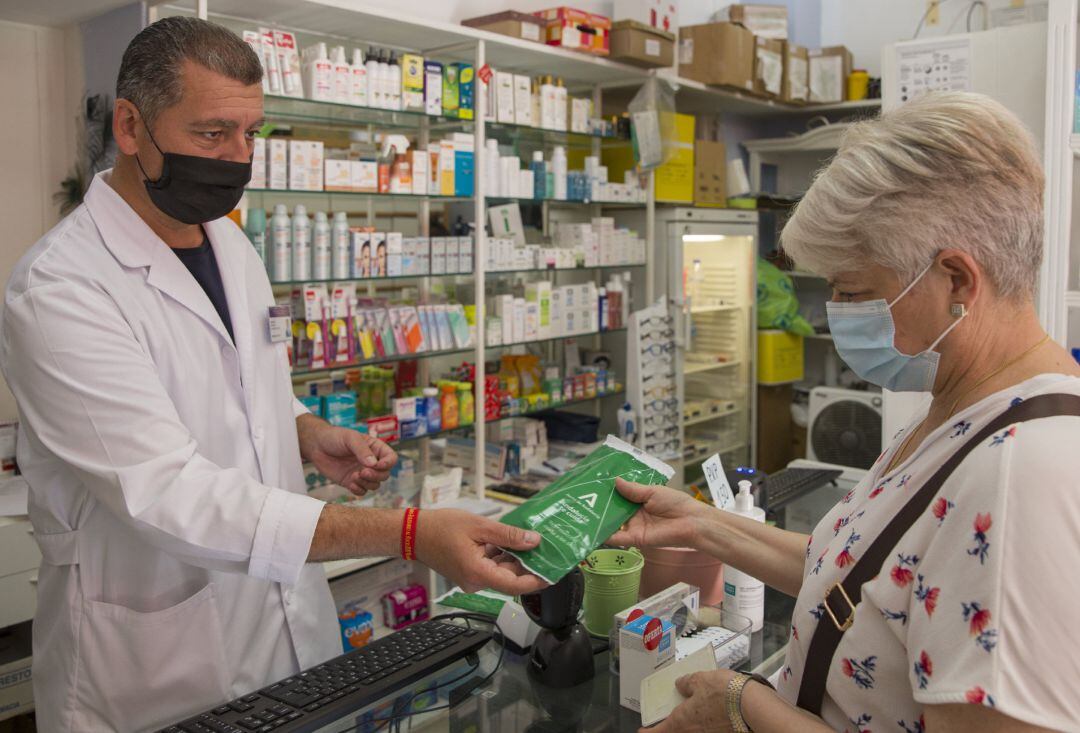 Una mujer adquiere las mascarillas gratuitas que la Junta de Andalucía en una imagen de archivo.