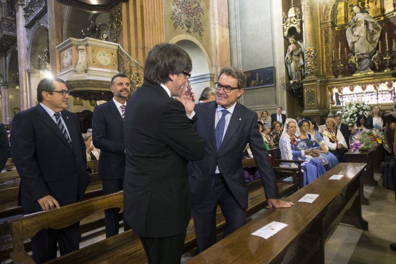 El presidente de la Generalitat de Catalunya, Carles Puigdemont (i), habla con el ex presidente Artur Mas, (d) antes del oficio de la Misa de la Mercè durante las fiestas de la patrona de la ciudad de Barcelona