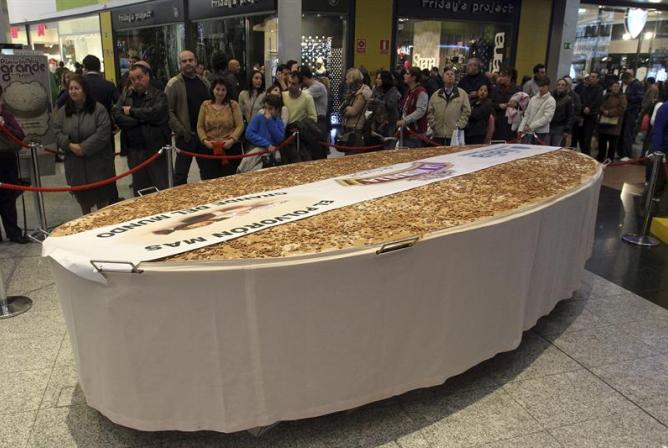 Vista del polvorón más grande del mundo, de cinco metros de largo por 2,40 de ancho y 300 kilos de peso, elaborado por una fábrica de dulces navideños de Estepa (Sevilla), que se ha dividido en 10.000 porciones de 30 gramosy que se ha repartido esta seman