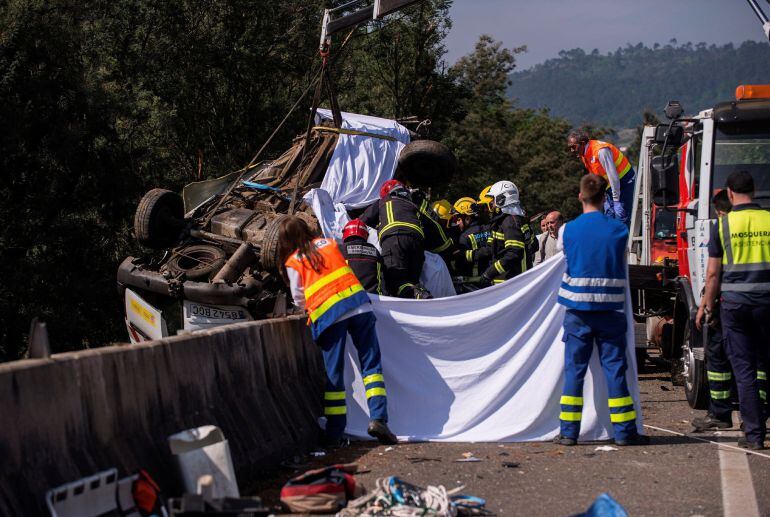 En la imagen, efectivos de bomberos tratan de excarcelar el cuerpo del conductor fallecido.