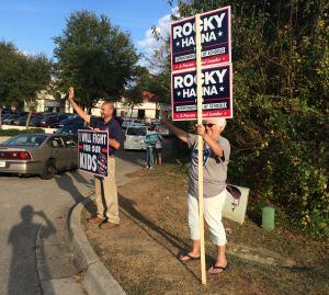 Seguidores de un candidato a las elecciones locales en Tallahassee saludan a los que llegan para ejercer el voto anticipado.