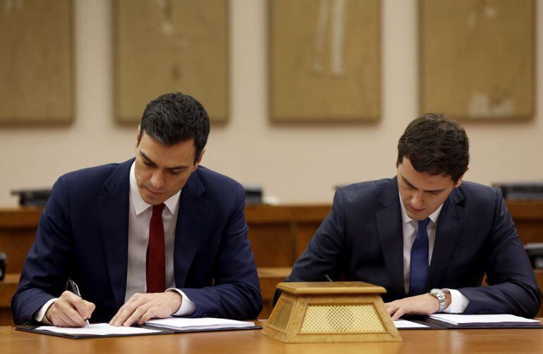 El secretario general del PSOE, Pedro Sánchez (i), y el presidente de Ciudadanos, Albert Rivera, durante la firma de un acuerdo de investidura y legislatura alcanzado entre los dos partidos, hoy en el Congreso de los Diputados