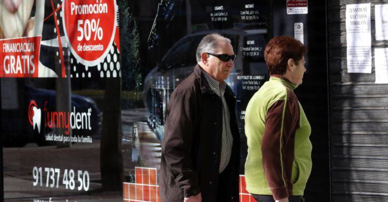 Dos personas leen los avisos dejados en la clínica Funnydent para los afectados por el cierre inesperado de los nueve centros que dispone en España la cadena