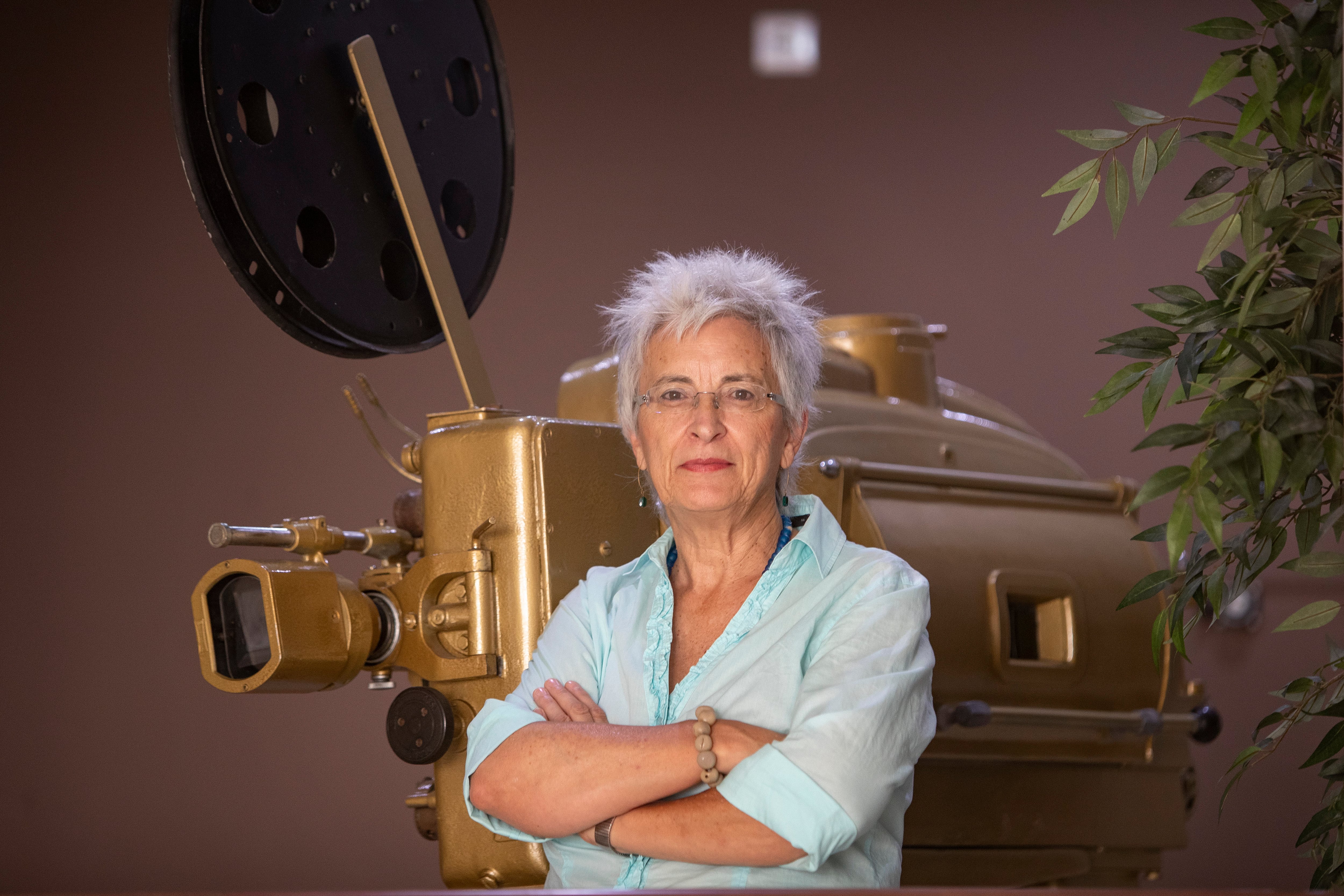 Oliva Acosta, directora de Generamma, el Festival de Cine Realizado por mujeres posa para EFE junto a un antiguo proyector de cine en el Teatro Moderno de Chiclana de la Frontera (Cádiz) donde se desarrolla la muestra. EFE/Román Ríos