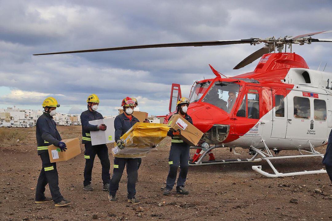 Bomberos de Lanzarote descargan el material para el estudio tras llegar a la isla.