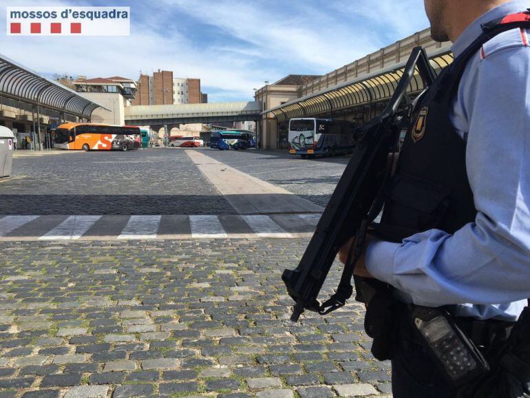 Un agent amb un subfusell a l'aparcament d'una estació d'autobusos