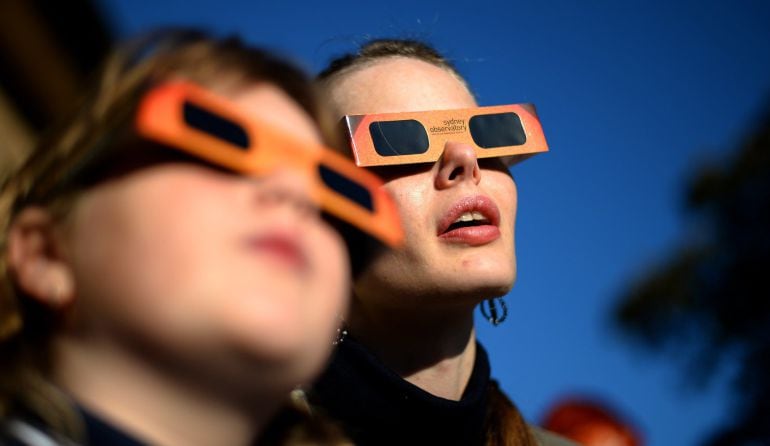 (FILES) This file picture dated May 10, 2013 shows people watching a partial solar eclipse at the Sydney Observatory. Die-hard eclipse junkies from around the world are expected to brave polar bears and frostbite in the Arctic on March 20, 2015 to savour three minutes of total darkness when the moon totally blocks the sun. The Norwegian archipelago of Svalbard, located 1,300 kilometres (800 miles) from the North Pole, is along with the Faroe Islands the only place the total eclipse will be visible. Elsewhere only a partial eclipse will be seen at best. AFP PHOTO / Saeed KHAN