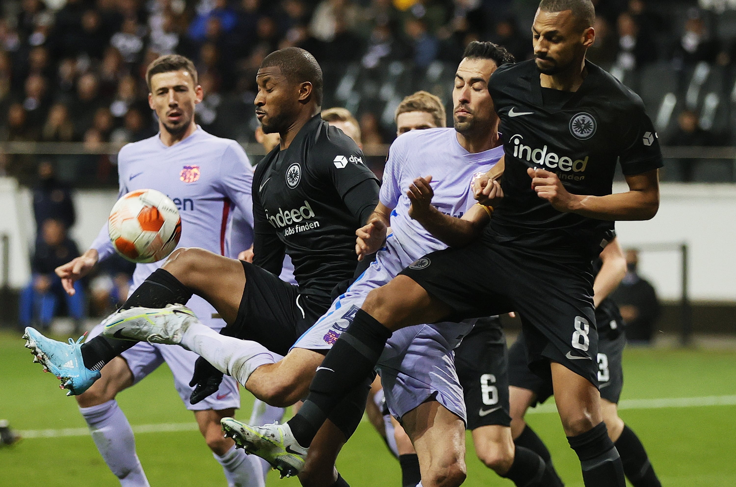 Frankfurt (Germany), 07/04/2022.- Djibril Sow (R) and Almamy Toure of Frankfurt in action against Sergio Busquets (C) of Barcelona during the UEFA Europa League quarter final, first leg soccer match between Eintracht Frankfurt and FC Barcelona in Frankfurt, Germany, 07 April 2022. (Alemania) EFE/EPA/RONALD WITTEK
