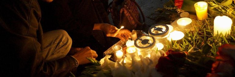 Members of the French community light candles at a memorial for the victims of Friday's Paris attacks