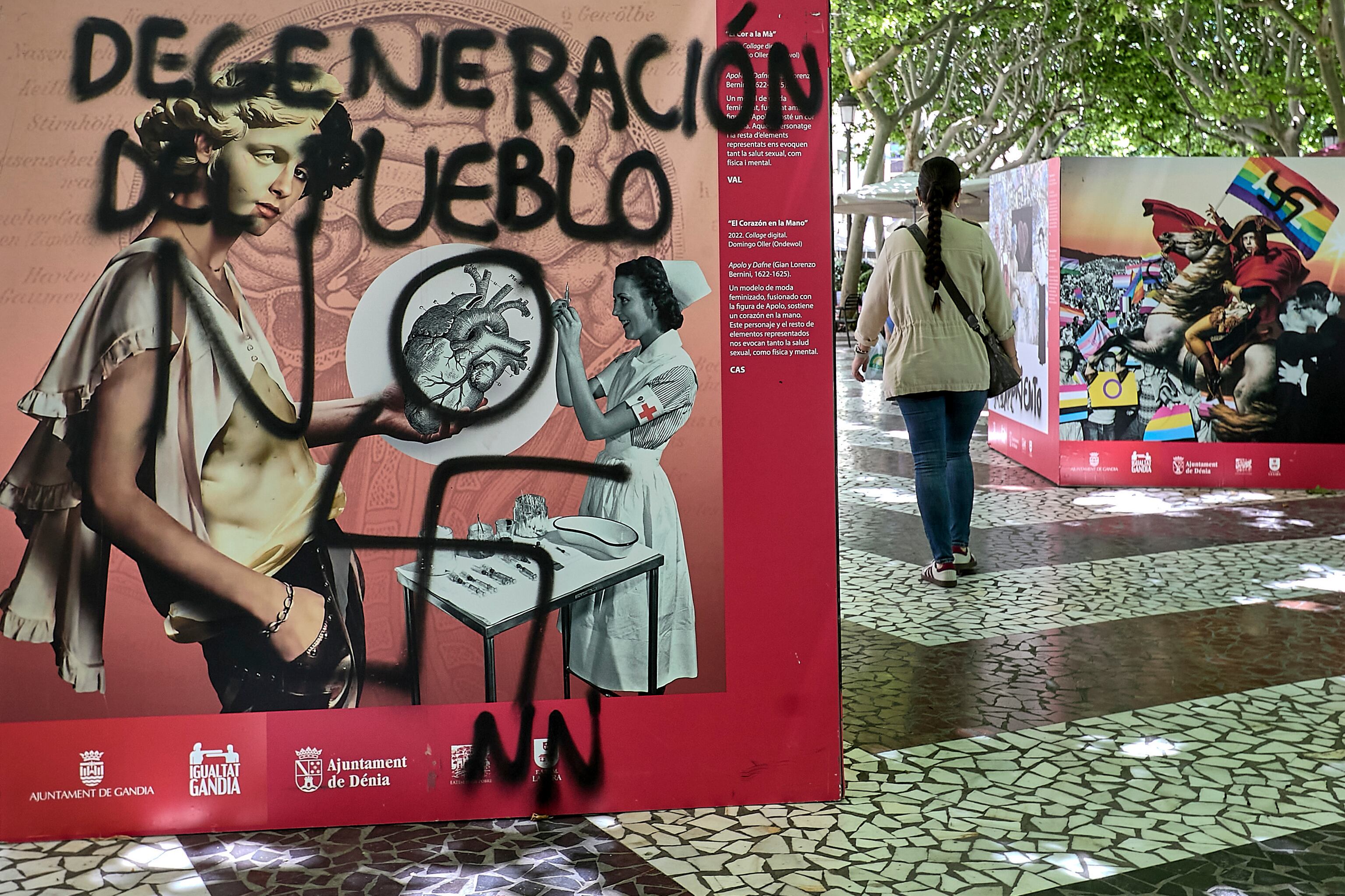 GRAFCVA7624. GANDÍA (VALENCIA), 20/05/2025.- Una persona recorre la exposición "Planificando la diversidad LGTBI+, Arte y Cultura", situada frente a la Casa de la Marquesa en Gandia (Valencia), que ha sido vandalizada con pintura negra durante la madrugada de este martes, un hecho que ha sido condenado por el Ayuntamiento, el PSPV-PSOE, el PP y Compromís. EFE/Natxo Francés