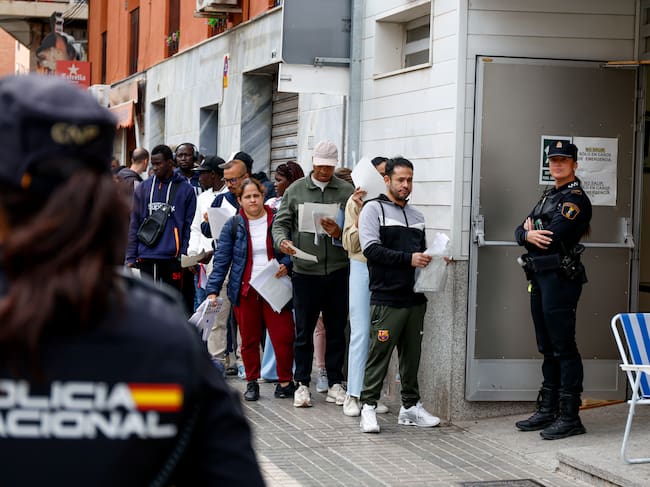 Decenas de personas hacen cola a las puertas de una Oficina de Atención a la Ciudadanía para presentar documentación dentro de su proceso de regularización. EFE/Pablo Miranzo
