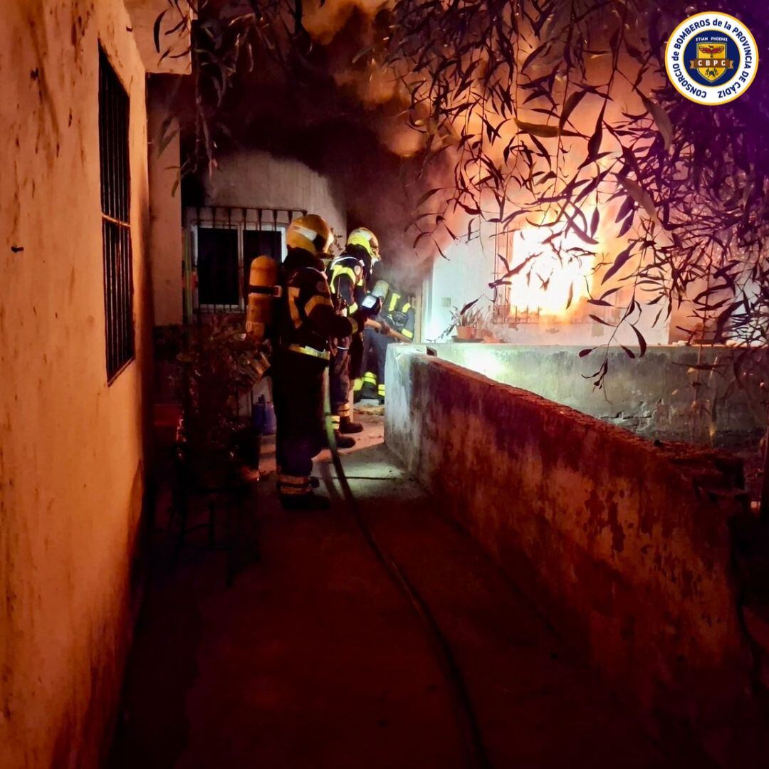Los bomberos sofocando el incendio este domingo en una vivienda de Jerez