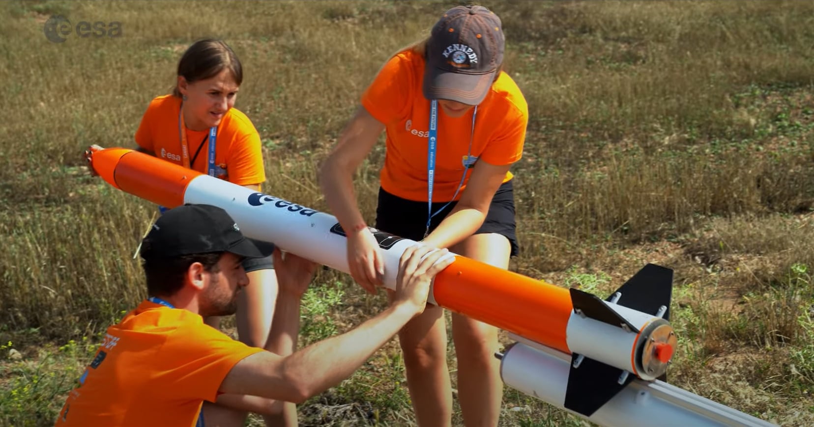 Un grupo de alumnos manipula un cohete para lanzar su CanSat