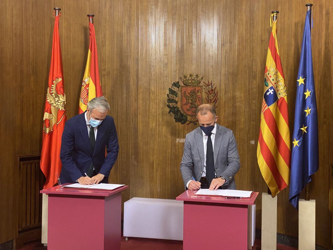 Jorge Azcón, a la izquierda, y Cristian Lapetra, a la derecha, firman el convenio en el Ayuntamiento de Zaragoza
