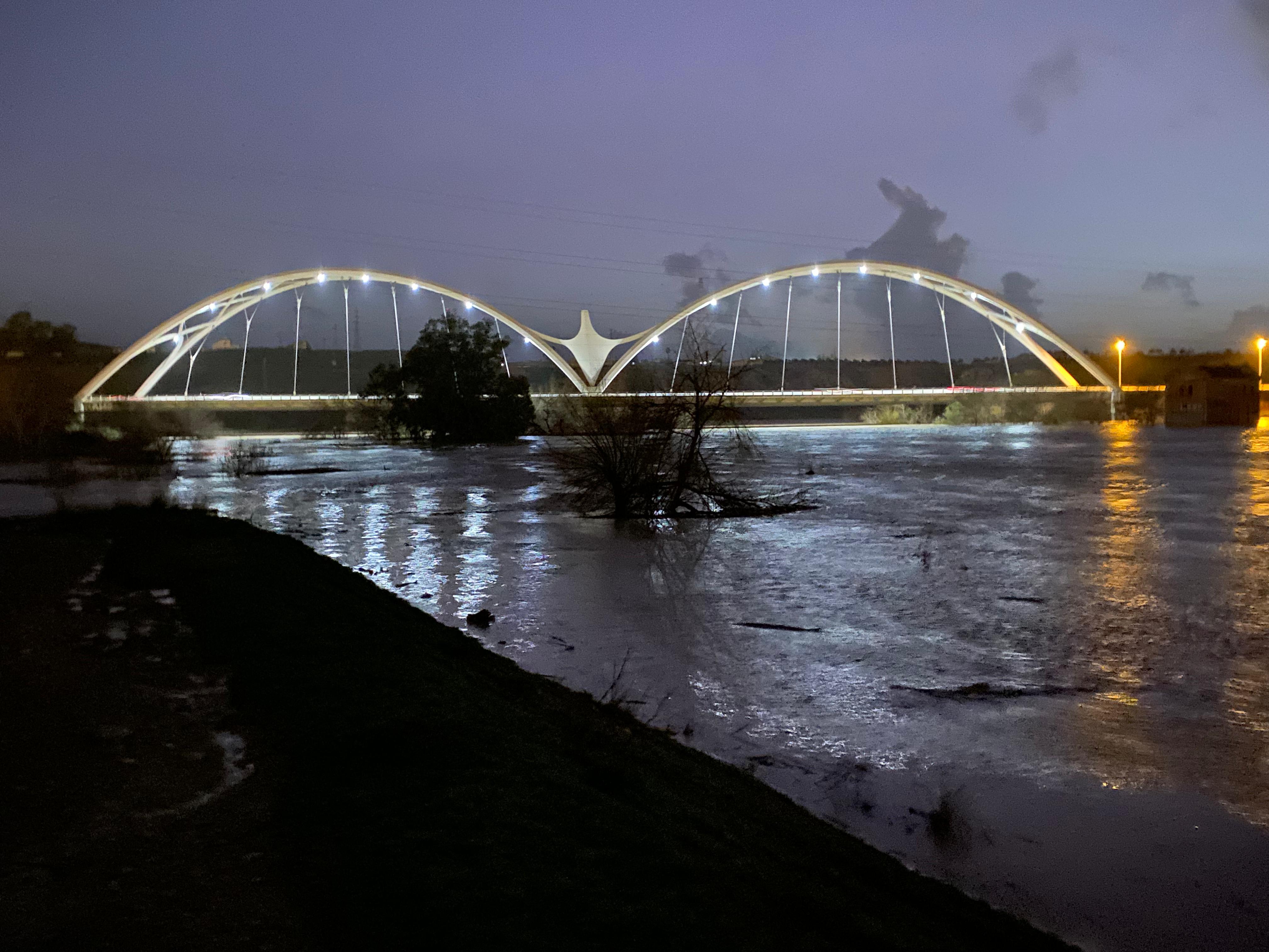 Panorámica nocturna de la crecida del Guadalquivir a su paso por el puente de Ibn Firnás en Córdoba