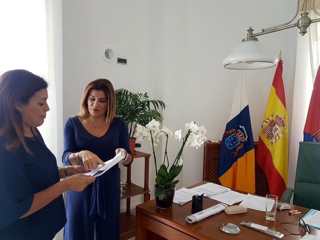 La alcaldesa de Arrecife, Ástrid Pérez, y la concejal de Bienestar Social, María Jesús Tovar, supervisan los detalles del pliego de condiciones del servicio.