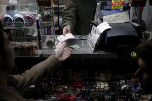 A customer purchases a Powerball lottery tickets at a news stand on Wall St. in New York January 13, 2016. Dreams of quitting an uninspiring job, helping the needy and traveling the world opened American wallets on Wednesday for a chance to win the bigges