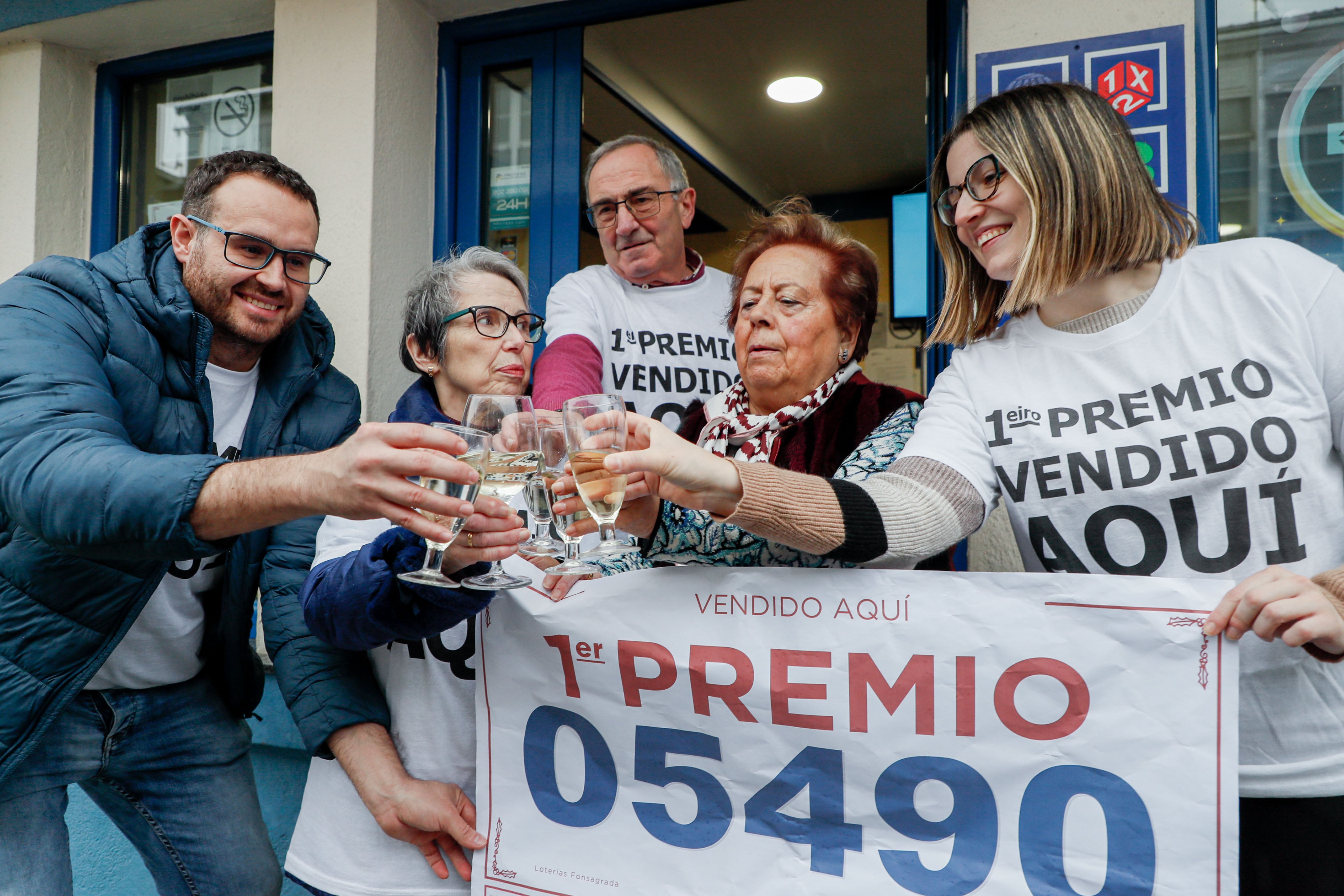 A FONSAGRADA (LUGO), 22/12/2022.- Propietarios y empleados de la administración número 1 de A Fonsagrada (Lugo) celebran haber vendido El Gordo, el número 05490, este jueves. EFE/ Eliseo Trigo
