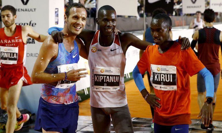 El keniano Eric Kiptanui (centro) posa junto a su compatriota Amos Kirui (derecha) y al español Toni Abadía (izquierda) tras lograr la primera, segunda y tercera posición en la San Silvestre Vallecana.