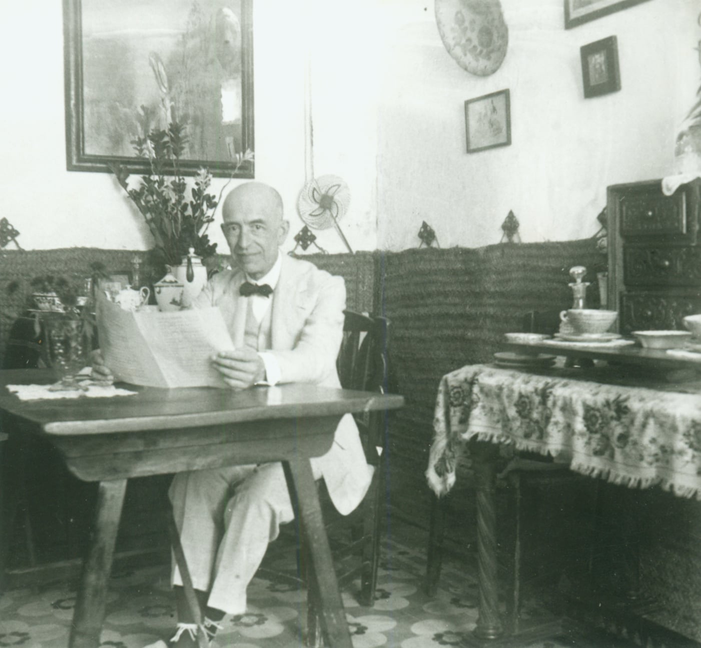 Manuel de Falla sentado, hojeando una partitura, en su casa de la Antequeruela. Granada, 1928.