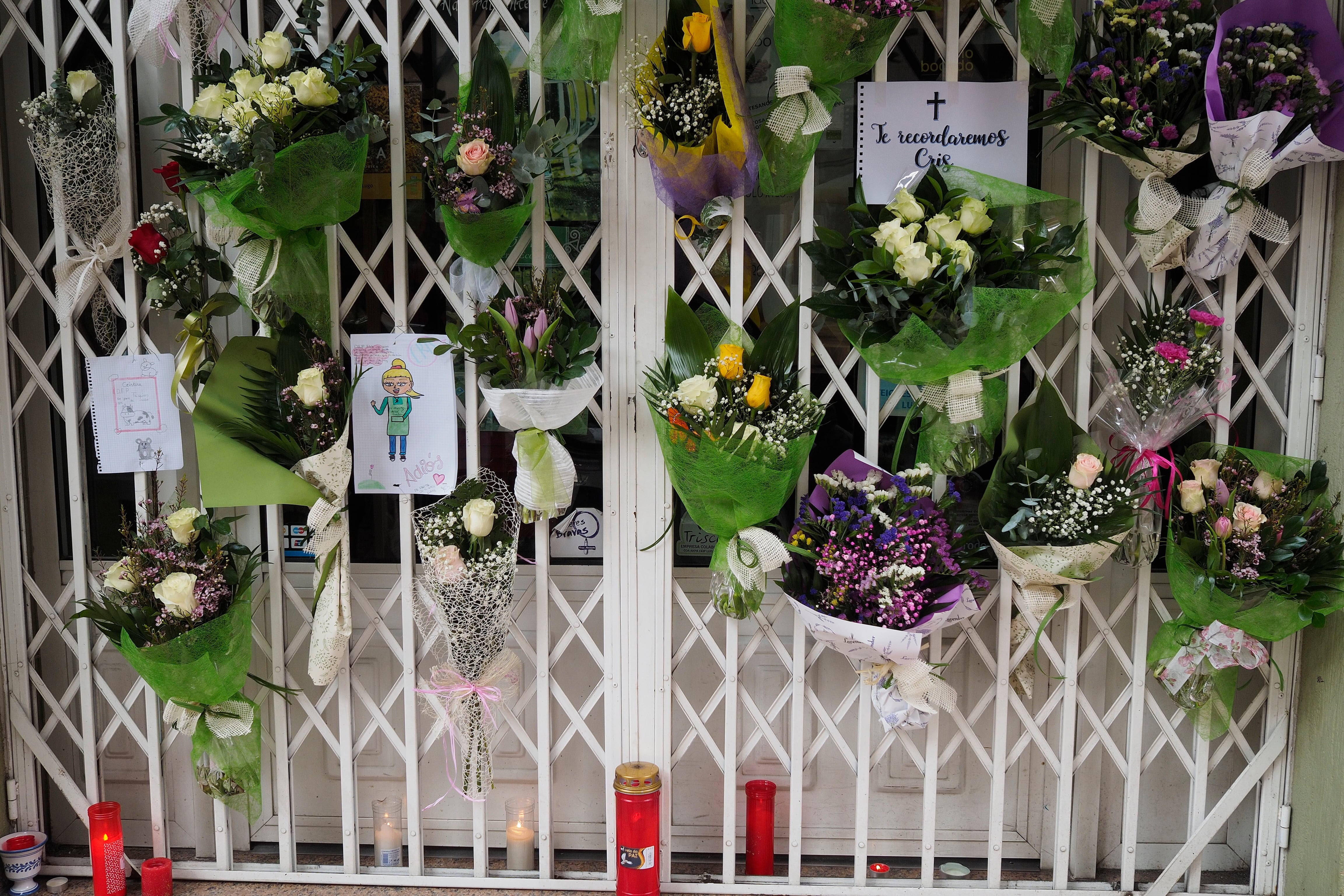 GRAF9028. LUGO, 29/11/2022.- Vecinos de la ciudad de Lugo dejan ramos de flores, mensajes escritos y velas encendidas en la puerta de la tienda de agricultura ecológica A despensa do avó Francisco que regentaba Cristina Cabo Buján, la mujer de 42 años asesinada a cuchilladas en su domicilio, en la Rúa Quiroga. EFE/ Eliseo Trigo
