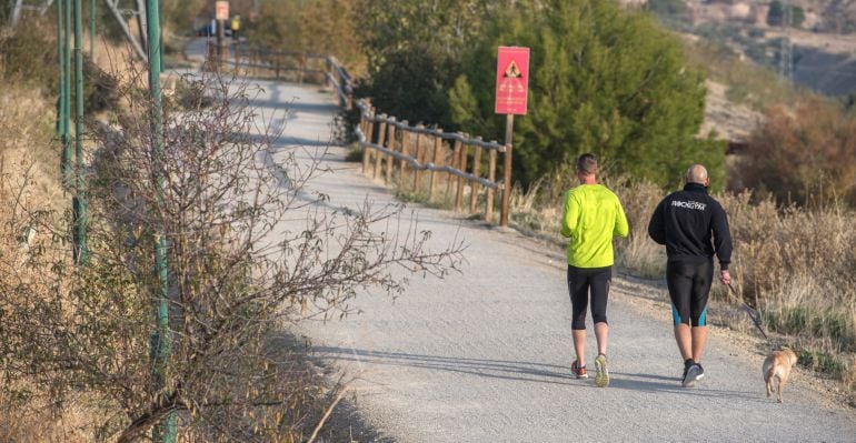 Dos personas corriendo por la Vía Verde del Aceite.