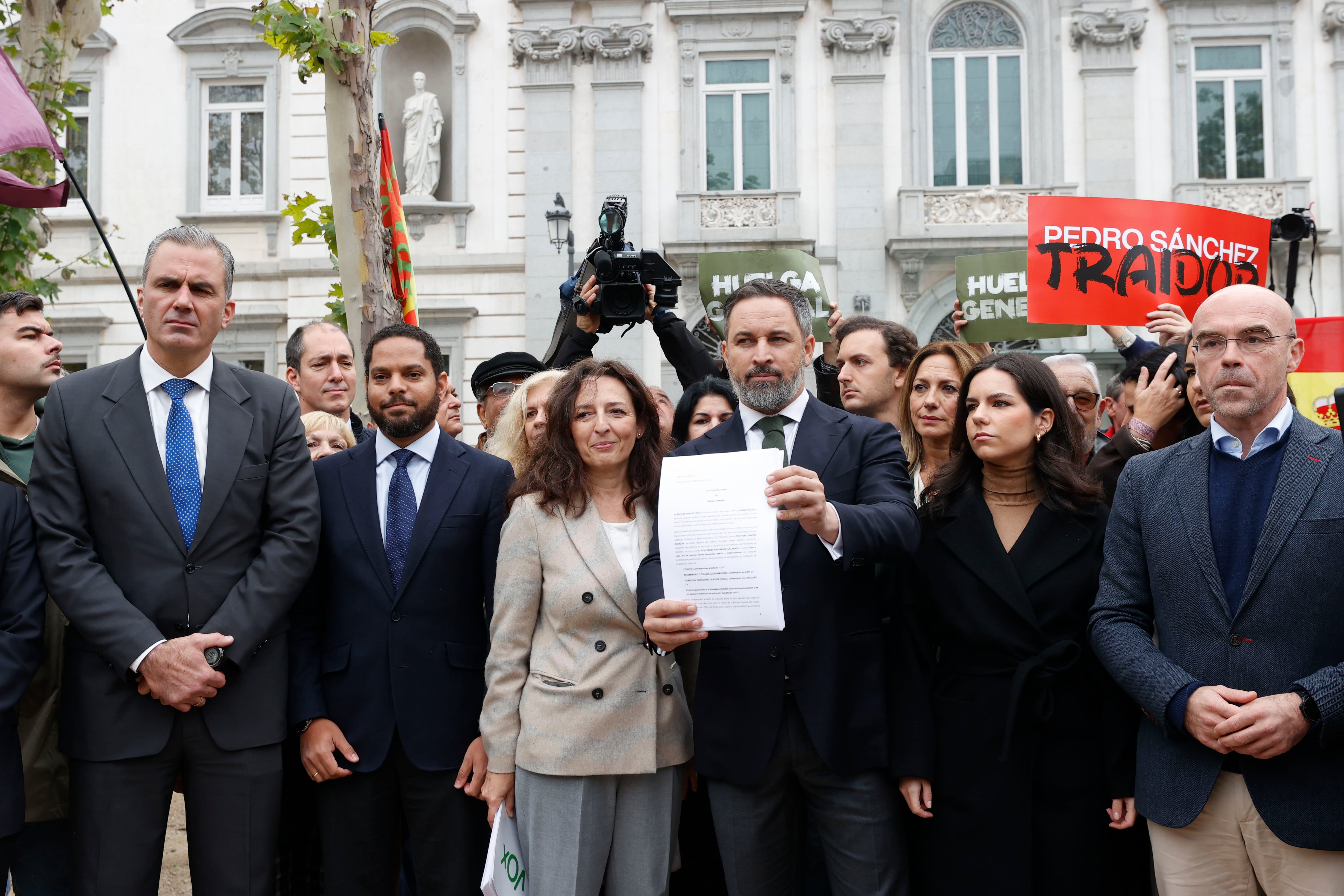 El presidente de Vox, Santiago Abascal, acompañado por los diputados Francisco Javier Ortega Smith (i), Ignacio Garriga (2i), Carina Mejías (3i), María José Rodríguez y el eurodiputado Jorge Buxadé (d), antes de presentar una querella contra el presidente del Gobierno en funciones, Pedro Sánchez, en la que pide la suspensión cautelar del pleno de investidura, este martes en el Tribunal Supremo.