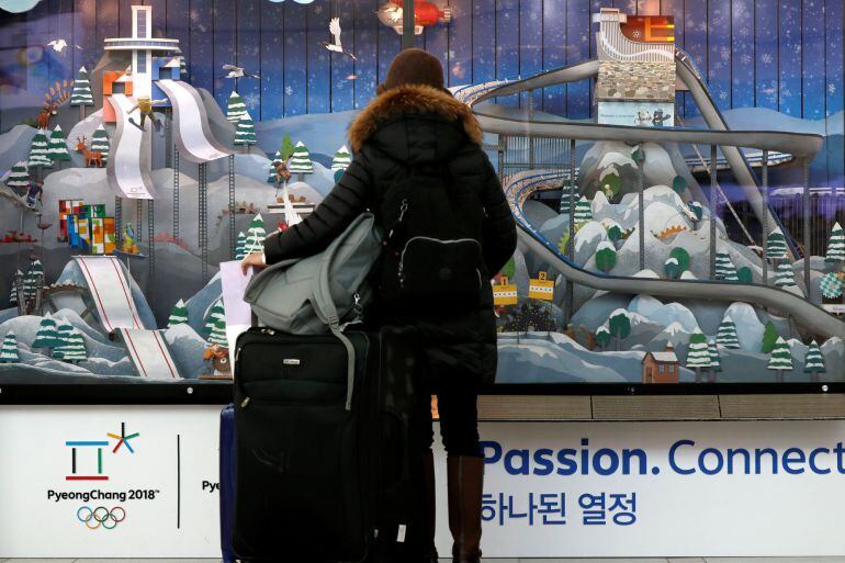 Una mujer observa un escaparate promocional de los Juegos Olímpicos de Invierno de PyeongChang 2018 en una estación de Seúl