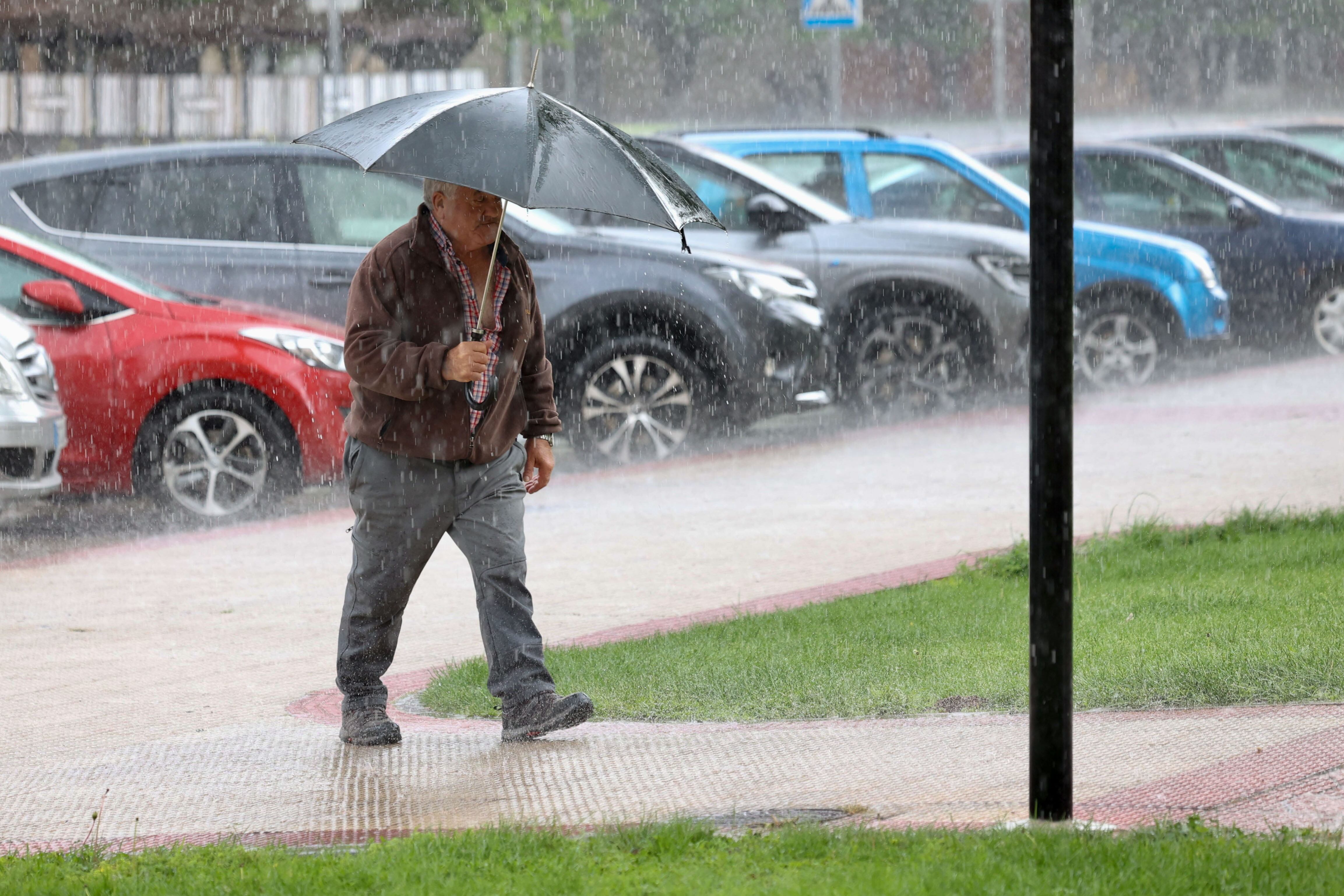 Un hombre se protege con paraguas de una fuerte tormenta en Logroño.