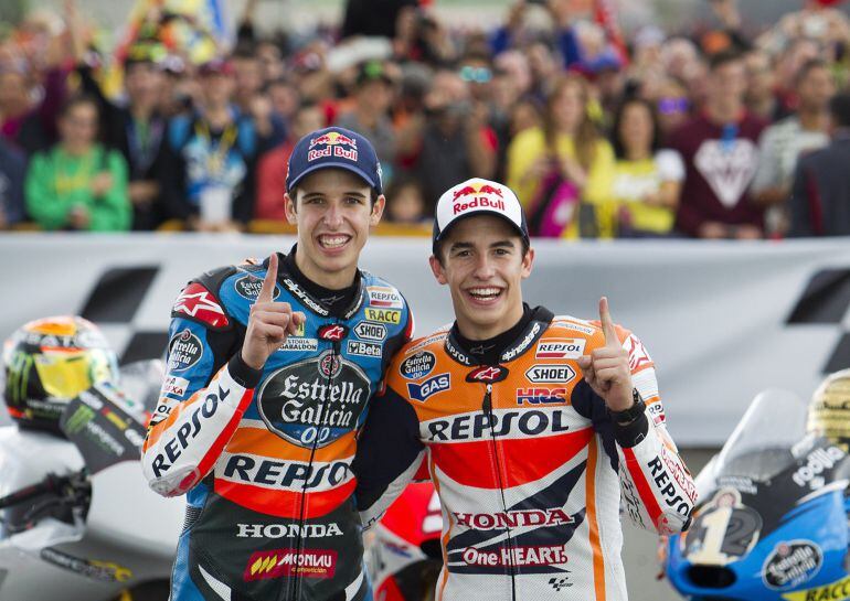 World Champions, Moto GP Repsol Honda's Spanish rider Marc Marquez (R) and his brother Moto 3 Estrella Galicia 0,0's Spanish rider Alex Marquez pose after winning the championship at the Ricardo Tormo racetrack in Cheste near Valencia on November 9, 2014. AFP PHOTO/ JAIME REINA