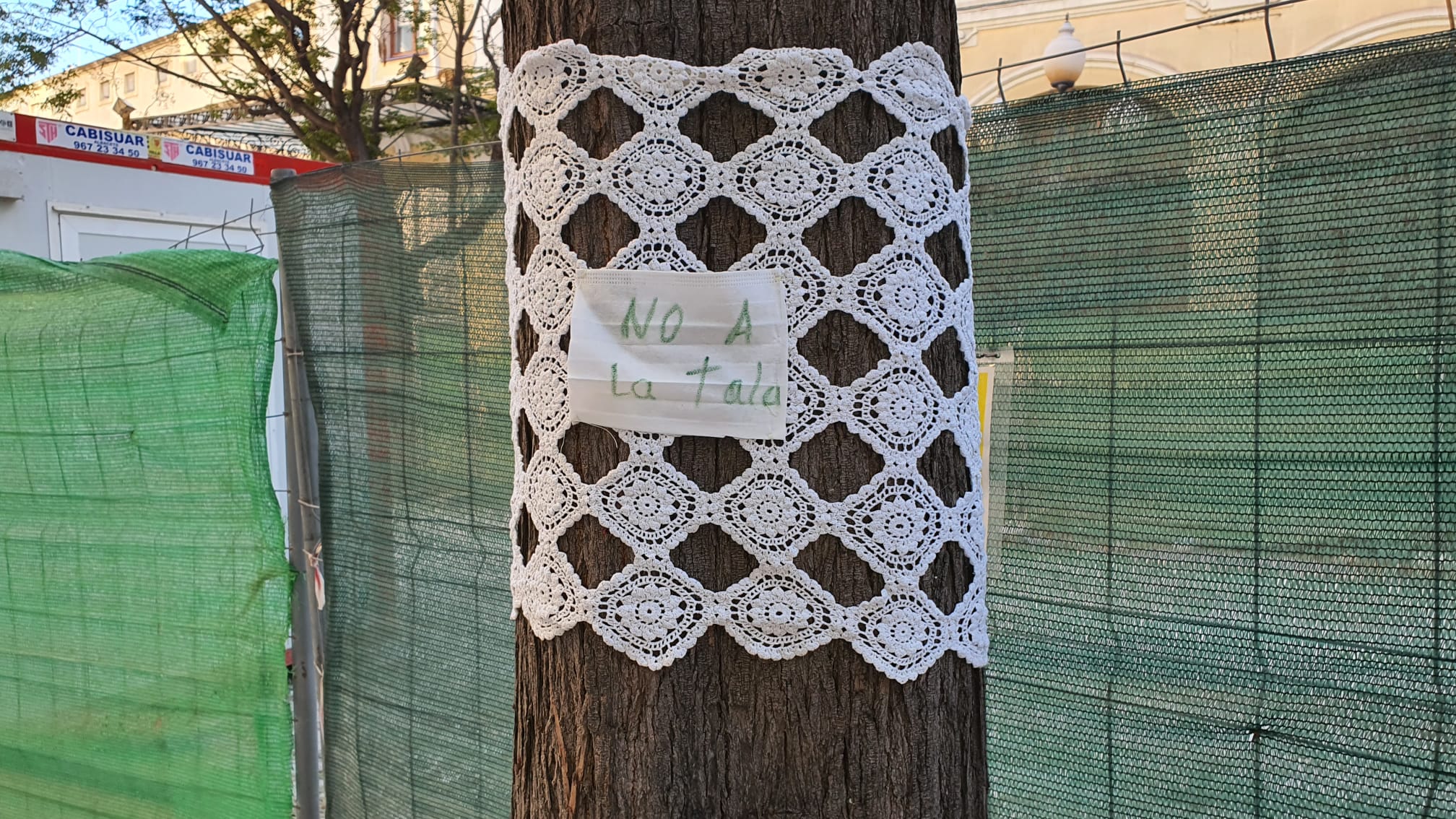 Los asistentes a la concentración han colgado carteles y piezas de ganchillo en contra de la tala de árboles