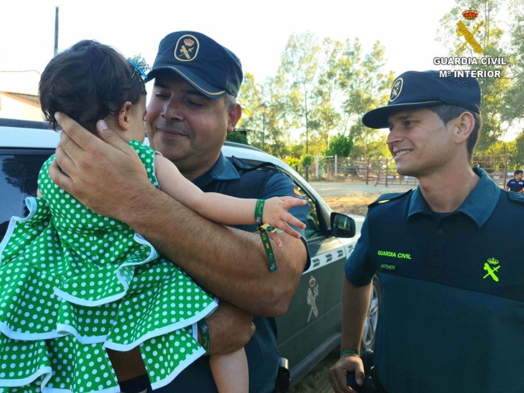 Los dos Guardia Civiles junto a la pequeña a la que salvan la vida en El Rocío (Almonte-Huelva)