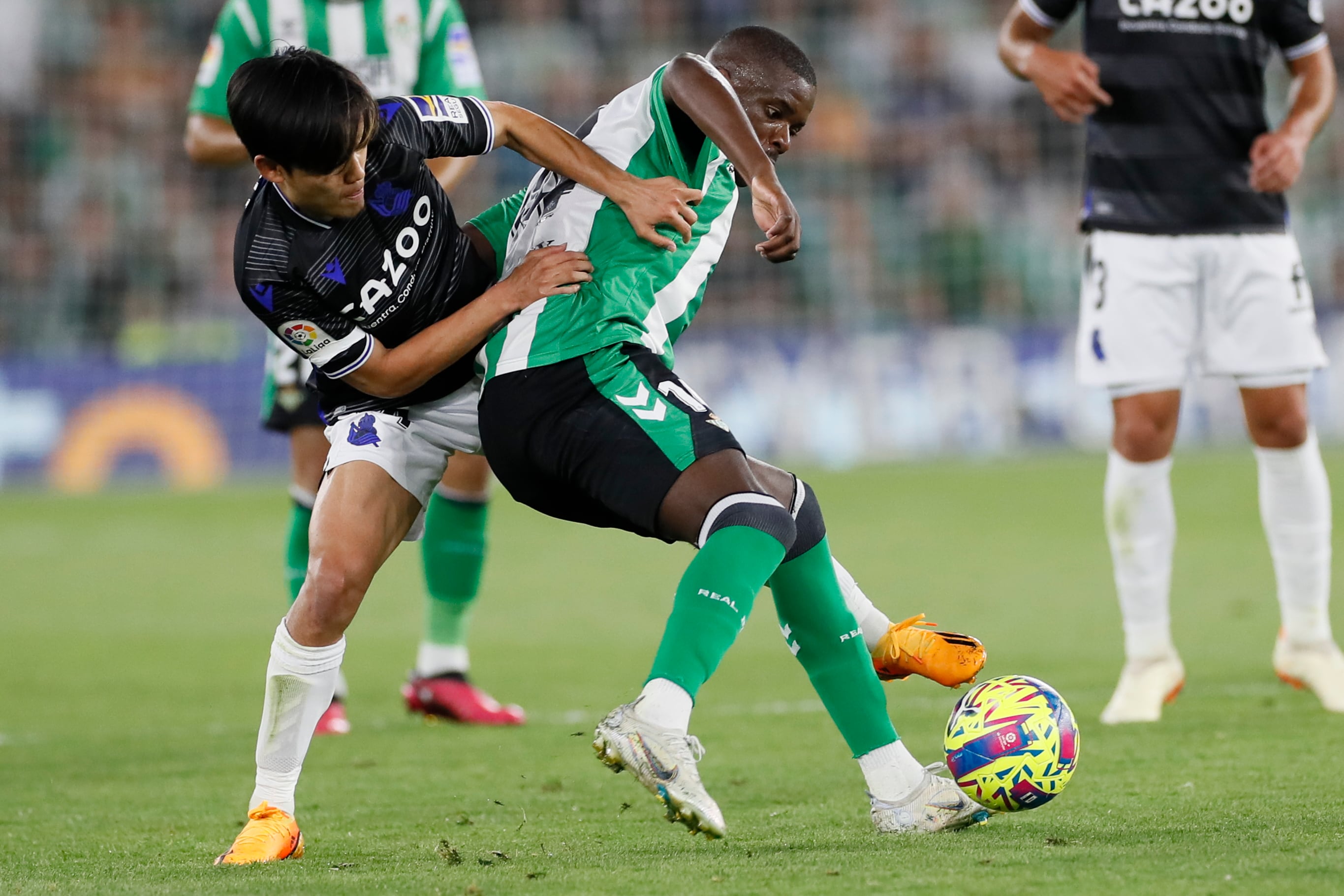 Sevilla, 25/04/2023.- El centrocampista portugués del Betis, William Carvalho (d), disputa el balón ante el centrocampista japonés de la Real Sociedad, Takefusa Kubo, durante el encuentro correspondiente a la jornada 31 de primera división disputado hoy martes en el estadio Benito Villamarín, en Sevilla. EFE/José Manuel Vidal.
