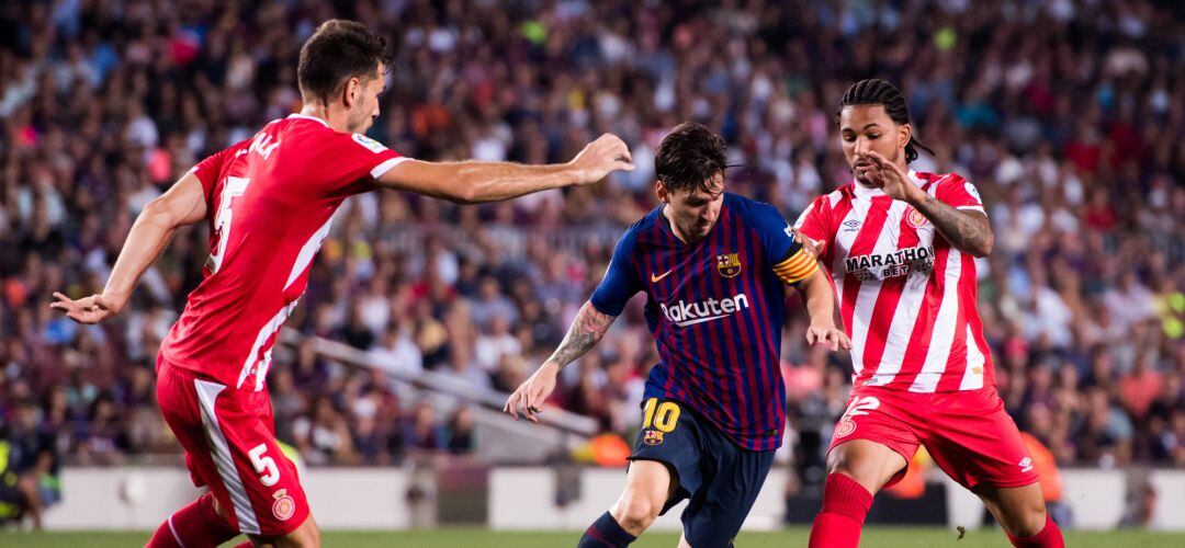 Leo Messi trata de zafarse de dos contrarios durante el partido ante el Girona