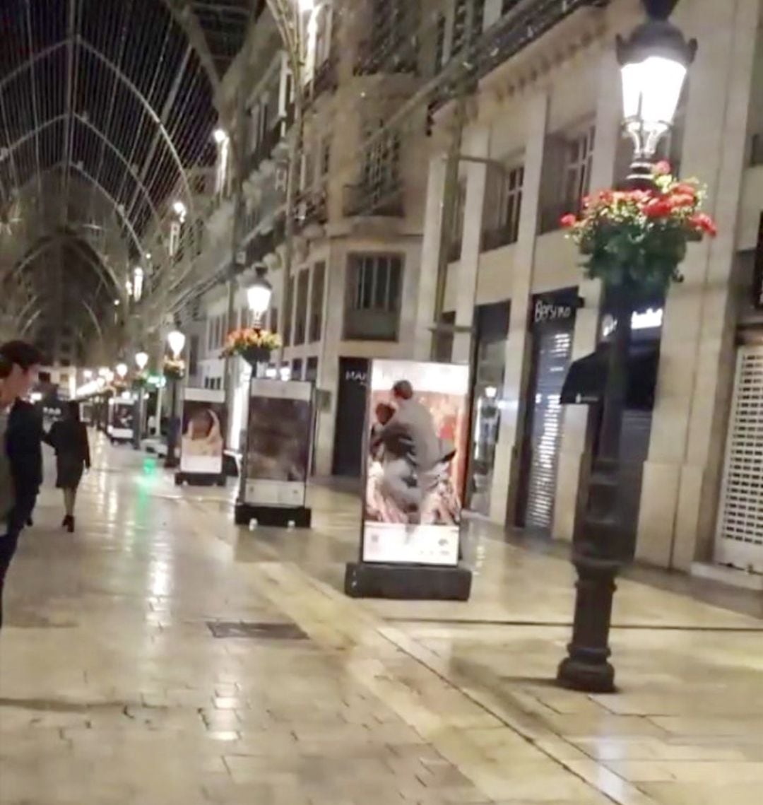 Uno de los jóvenes en el momento de estrellarse contra la imagen de la muestra en la calle Larios de Málaga