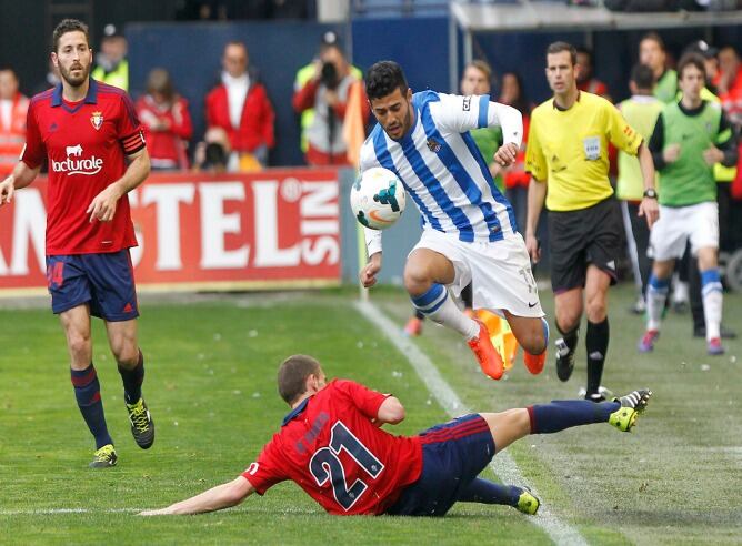 El mejicano Carlos Vela salta ante la entrada de Roberto Torres