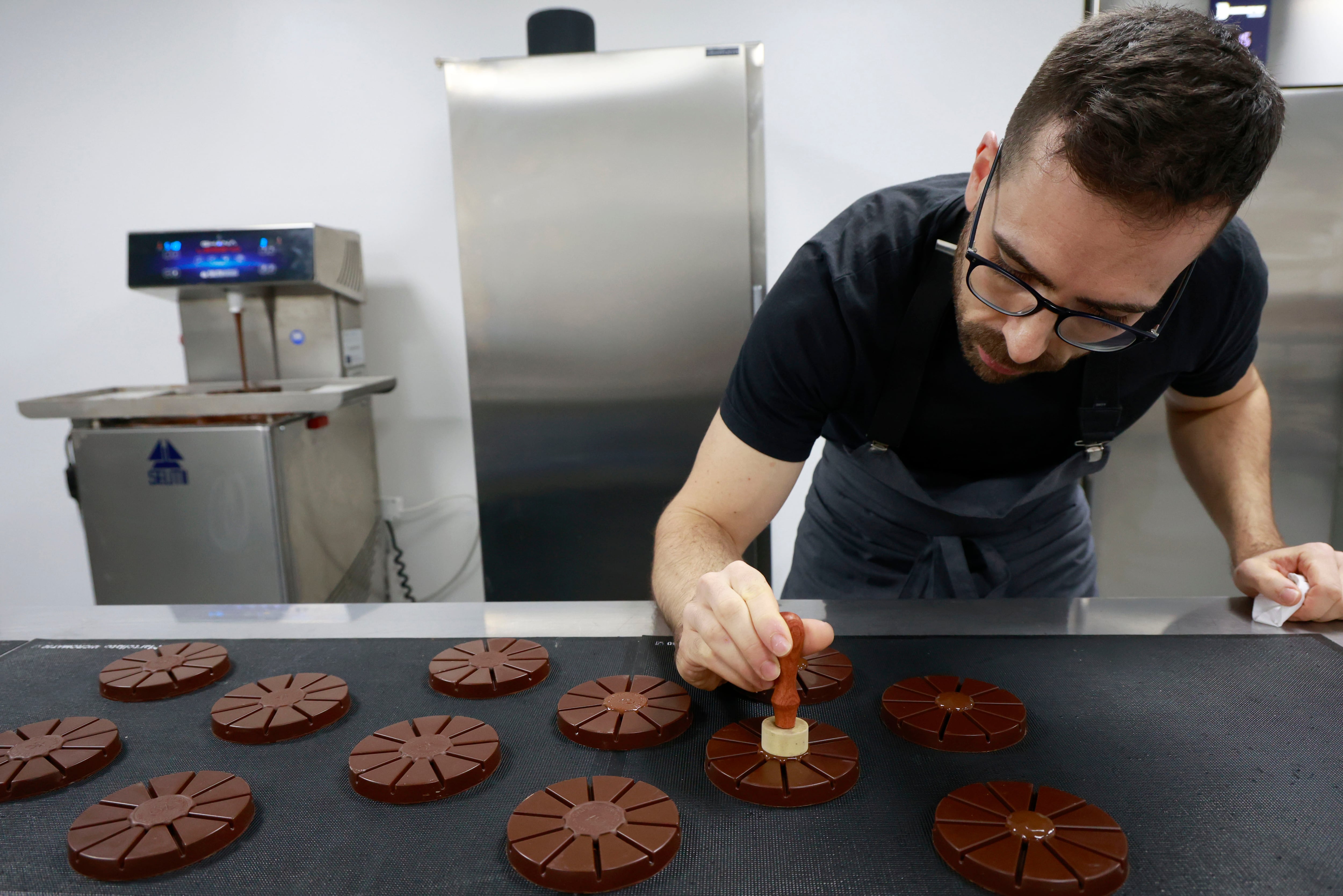 Pontedeume, 12/12/2024.-Un año después de su estreno, la marca de chocolates Oxóco, que los elabora con productos como alga percebe o eucalipto, se lanza al mercado de los turrones con una apuesta por recuperar los sabores tradicionales del producto protagonista de la Navidad; en la imagen, Tomás Rodríguez en su obrador dando los últimos toques a unos turrones. EFE/ Kiko Delgado.