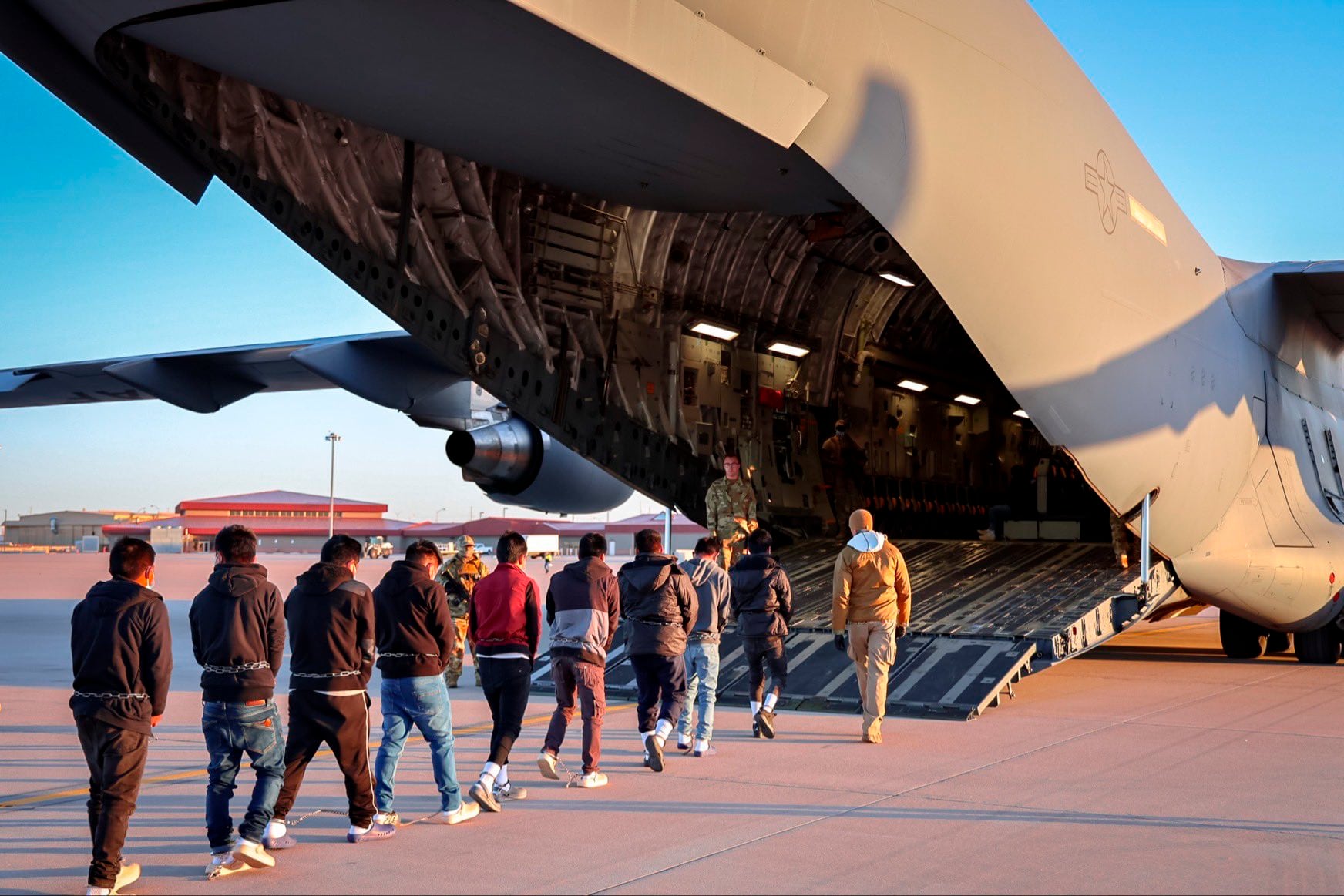 Migrantes ingresando a un avión para un vuelo de deportación. 